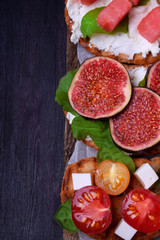 Assortment of bruschettas against the dark background. Copy space