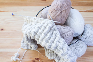 Balls of wool of natural colors on a wooden background. Copy space. Women's hobby and crafts. The concept of earning needlework. Top view