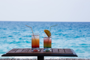 Two Colorful Tropical Cocktails on the Background of Warm Blue Sea. Happy Summer Vacation Concept.
