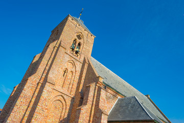 Fototapeta na wymiar Ancient church in a dutch village in sunlight at fall