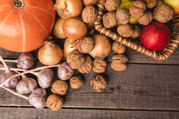 Top view for healthy, natural autumn harvest. On the old boards are pumpkin, nuts, fruits, garlic and onions. Free space for lettering. Flat-lying