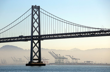 Morning view of Bay bridge with the industries in the fog, California