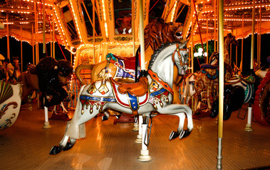 an old carousel with horses and other animals in an amusement park. night time.Merry-go-round with horses.