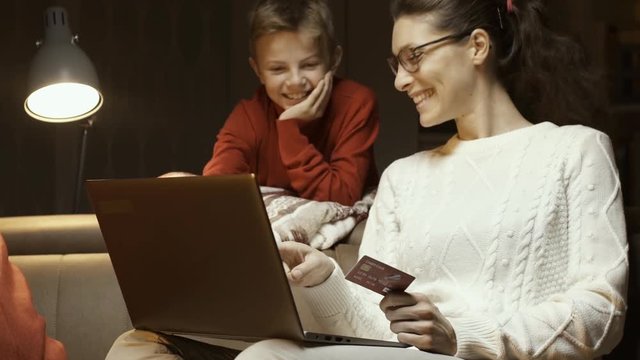Happy woman and her son doing online shopping