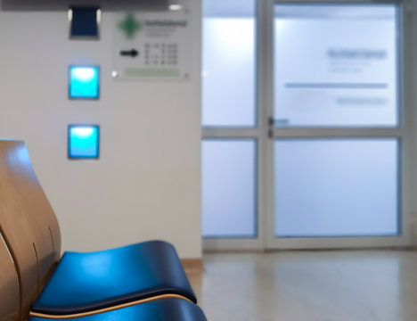 Wartebereich in der Notaufnahme. Eine Sitzgruppe vor einer beleuchteten Glast&uuml;r. Aufnahme im Krankenhaus.