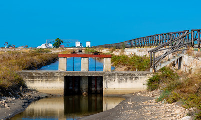 Hydraulic gateway with wooden gate in sea salt channel of Margherita di Savoia, Puglia. Italy