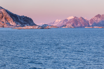 Naklejka premium Sunset over the sea during the ferry trip to Lofoten islands (Norway) in winter