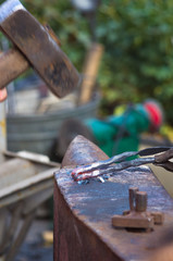 blacksmith performs the forging of hot glowing metal on the anvil