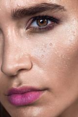 Naklejka premium Close up gamour beauty woman portrait. Fashion wet shiny skin, with drops sexy gloss lips make-up and pink eyebrows