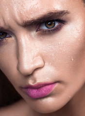 Close up glamour beauty woman portrait. Fashion wet shiny skin, with drops sexy gloss lips make-up and pink eyebrows