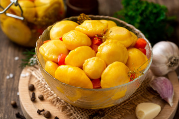 Marinated pattypan squash in glass bowl on dark rustic wooden background. Selective focus.