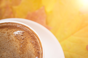 Autumn leaves and coffee cup over wood background with copy space, close up image