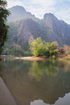 Scenic view of limestone karst mountains and the Nam Song River near Vang Vieng, Vientiane Province, Laos, on a sunny day.