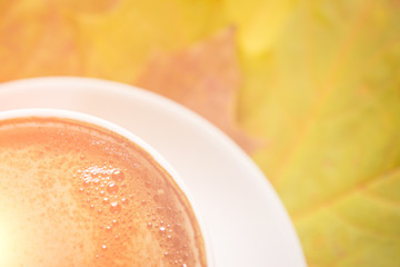 Autumn leaves and coffee cup over wood background with copy space, close up image