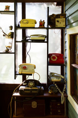 Vintage rotary telephones on the shelf as part of the collection and old chests. Russia, reportage photo.