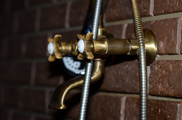 braun sanitary faucet in sauna on the red brick wall
