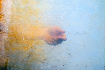emotional hand behind dirty textured glass