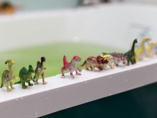 a lot of different toy dinosaurs at the bathroom.