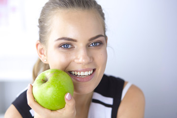 Young beautiful smiling girl with a green apple in hands