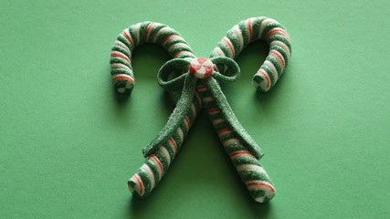 two candy canes tied together with a bow on a green background