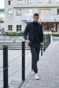 Confident young man walking on a European city street