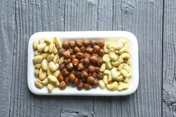 Assortment of nuts on a dark wooden table. View from above