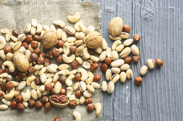 Assortment of nuts on a dark wooden table. View from above