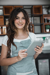 woman coffee shop worker using tablet pc
