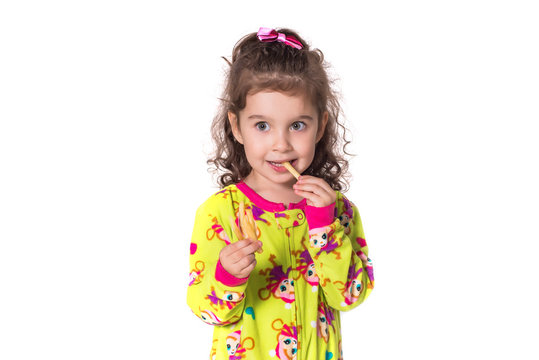 Pretty little girl eating french fries, isolated on white background.