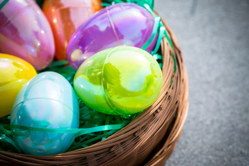 Multi-colored plastic Easter eggs in a circular brown basket