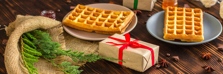 fresh belgian Tasty waffles and gifts on a wooden background. top view.
