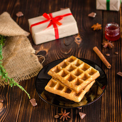 fresh belgian Tasty waffles and gifts on a wooden background. top view.
