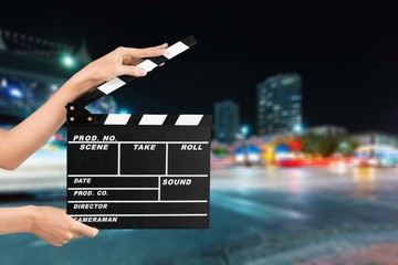 Cinema clapperboard in female hands on blue