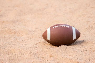 American football in the sand on the beach