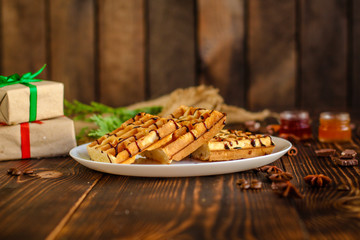 fresh belgian Tasty waffles and gifts on a wooden background. top view.