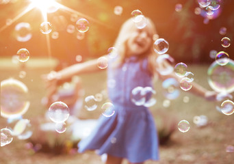 Cheerful little girl enjoying bubble blowing
