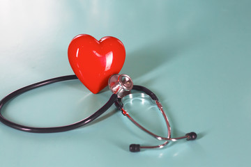 Red heart and a stethoscope on desk