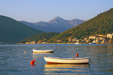 Fototapeta na wymiar Beautiful Mediterranean landscape with two fishing boats on the water. Montenegro, Adriatic Sea, view of Bay of Kotor near Tivat city