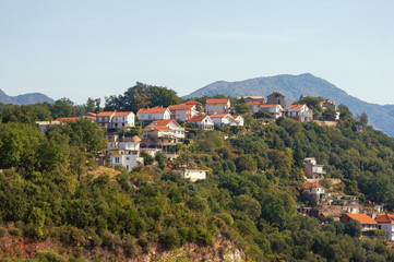 Naklejka na ściany i meble Beautiful mountain landscape with houses with red roofs on the mountainside. Montenegro, Herceg Novi