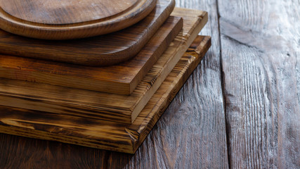 selective focus of stack of different wooden cutting boards on wooden table