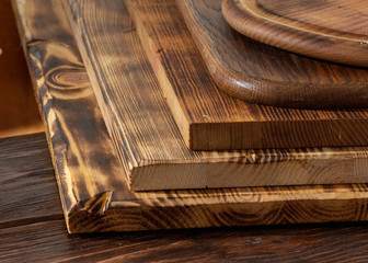 selective focus of stack of different wooden cutting boards on wooden table