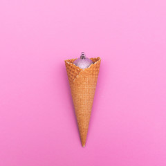 Ice cream cone with glitter silver ball. Christmas decoration, winter holidays concept. minimalism