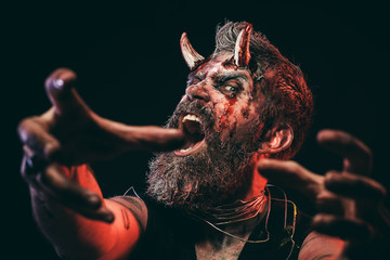 Halloween man devil satan with horns stretch zombie hands