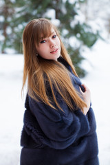 Beautiful elegant brunette woman wearing fur coat