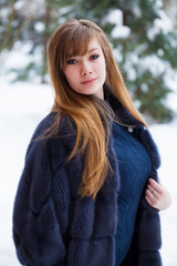 Beautiful elegant brunette woman wearing fur coat