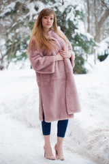 Beautiful elegant brunette woman wearing fur coat