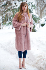 Beautiful elegant brunette woman wearing fur coat