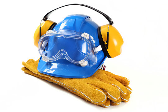 Sprzęt ochronny dla pracownika zawierający niebieski kask ochronniki słuchu gogle ochronne i rękawice robocze