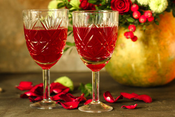 red wine in a glass and flowers on a wooden background. top view.