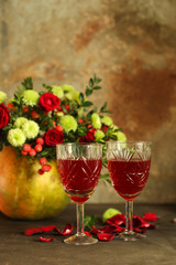red wine in a glass and flowers on a wooden background. top view.